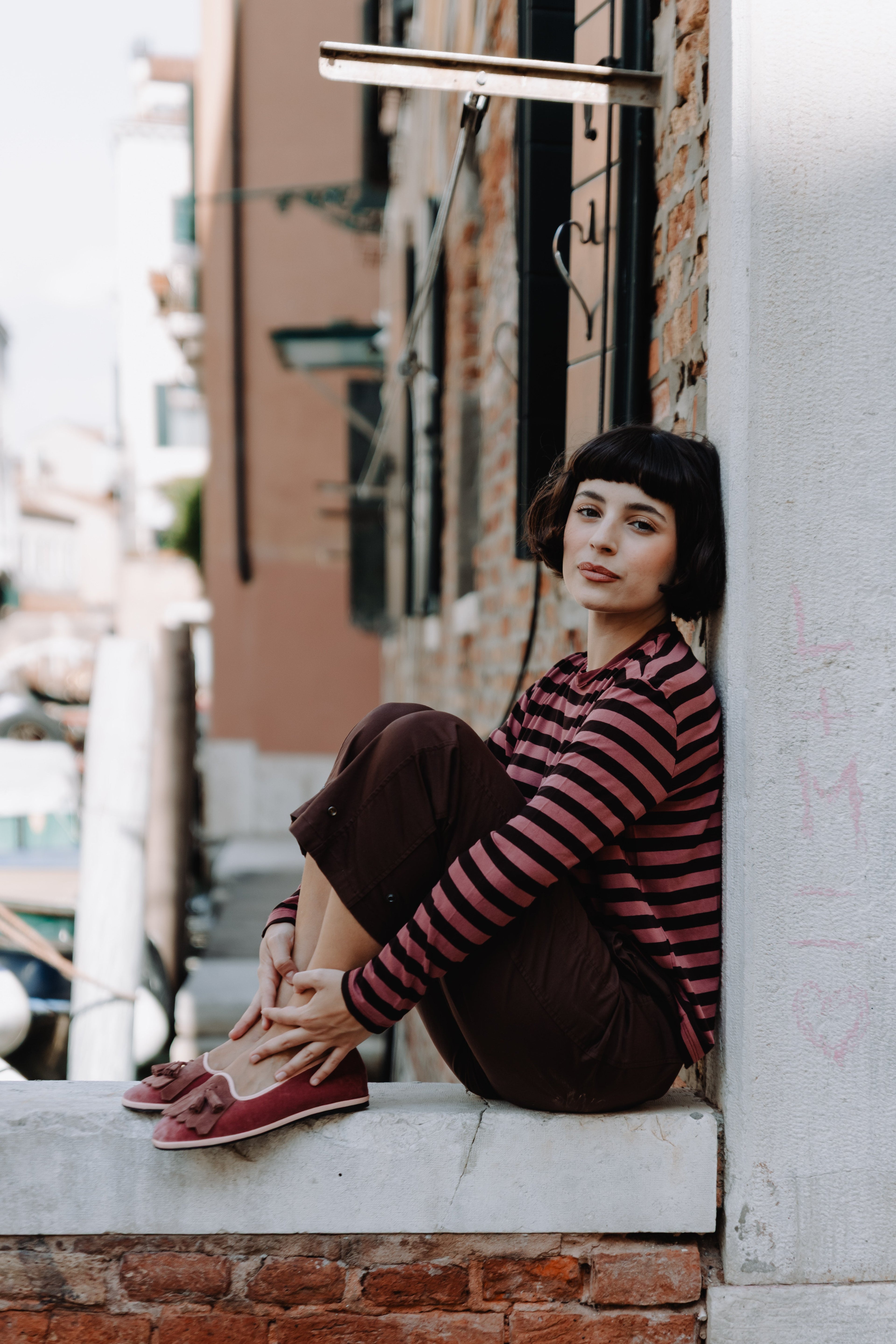 Handcrafted Gondolina Faloria fringe tassel flats in pink velvet, featuring authentic Venetian design, worn by model