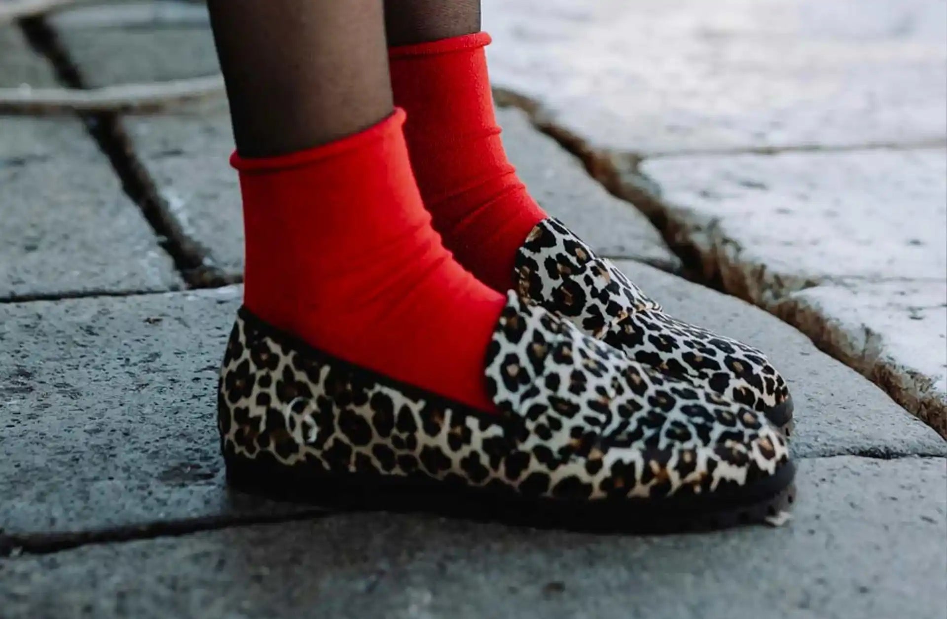 Loafers aa fantasia leopardata Gondolina indossate da una modella con calzino rosso e calza velata nera
